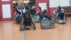 Frauen und M&auml;nner spielen Rugby im Rollstuhl