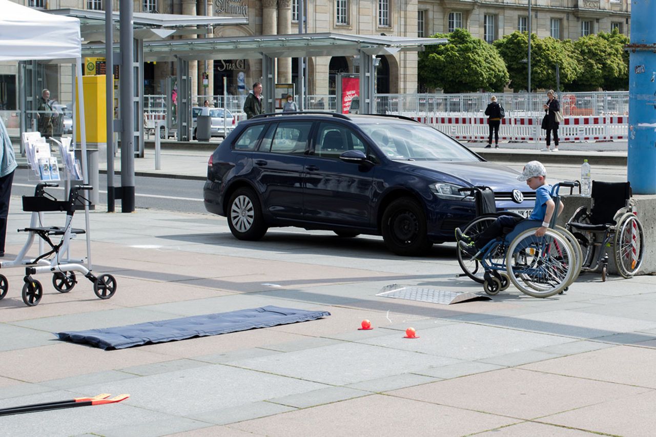 Ein kleiner Junge probiert den Rollstuhl-Parcours aus.