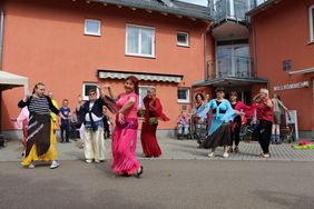 Mehrere Menschen tanzen vor dem "Haus Kirsche" der Diakonie in Auerbach