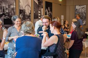 Frauen und Männer um den Stehtisch reden miteinander