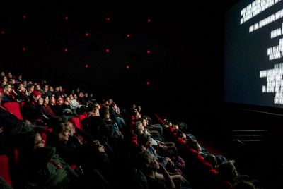 Gefüllter Kinosaal. Die Zuschauer blicken auf die Leinwand, auf der gerade der Abspann läuft.