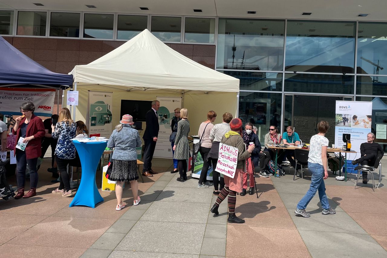 Viele Menschen stehen an den Ständen. Dort sind Michael Welsch und Manuela Scharf zu sehen.