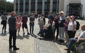 Eine Gruppe von Menschen mit Behinderung während einer inklusiven Stadtführung