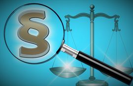 Eine Lupe die ein Paragraphensymbol vergr&ouml;&szlig;ert vor einer Waage