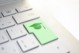 Das Bild zeigt einen kleinen Ausschnitt einer Tastatur. Die Enter Taste ist dabei grün eingefärbt und es ist ein Doktorhut-Symbol darauf abgebildet.