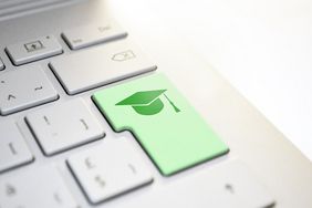 Das Bild zeigt einen kleinen Ausschnitt einer Tastatur. Die Enter Taste ist dabei grün eingefärbt und es ist ein Doktorhut-Symbol darauf abgebildet.