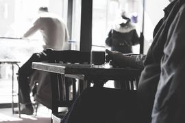 Mann sitzt am Tisch mit Kaffeetasse