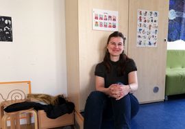 l&auml;chelnde Frau mit langen Haaren sitzend vor einem Schrank