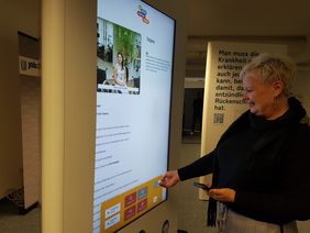 Frau Herrmann vom Berufsbildungswerk Dresden schaut sich die Medienstation an