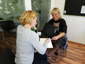 Zwei Frauen am Tisch mit Laptop im Gespr&auml;ch