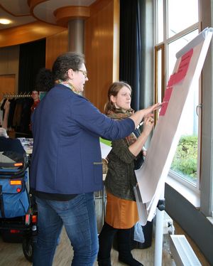 Teilnehmer vom 1. Netztreffen beraten sich am Flipchat