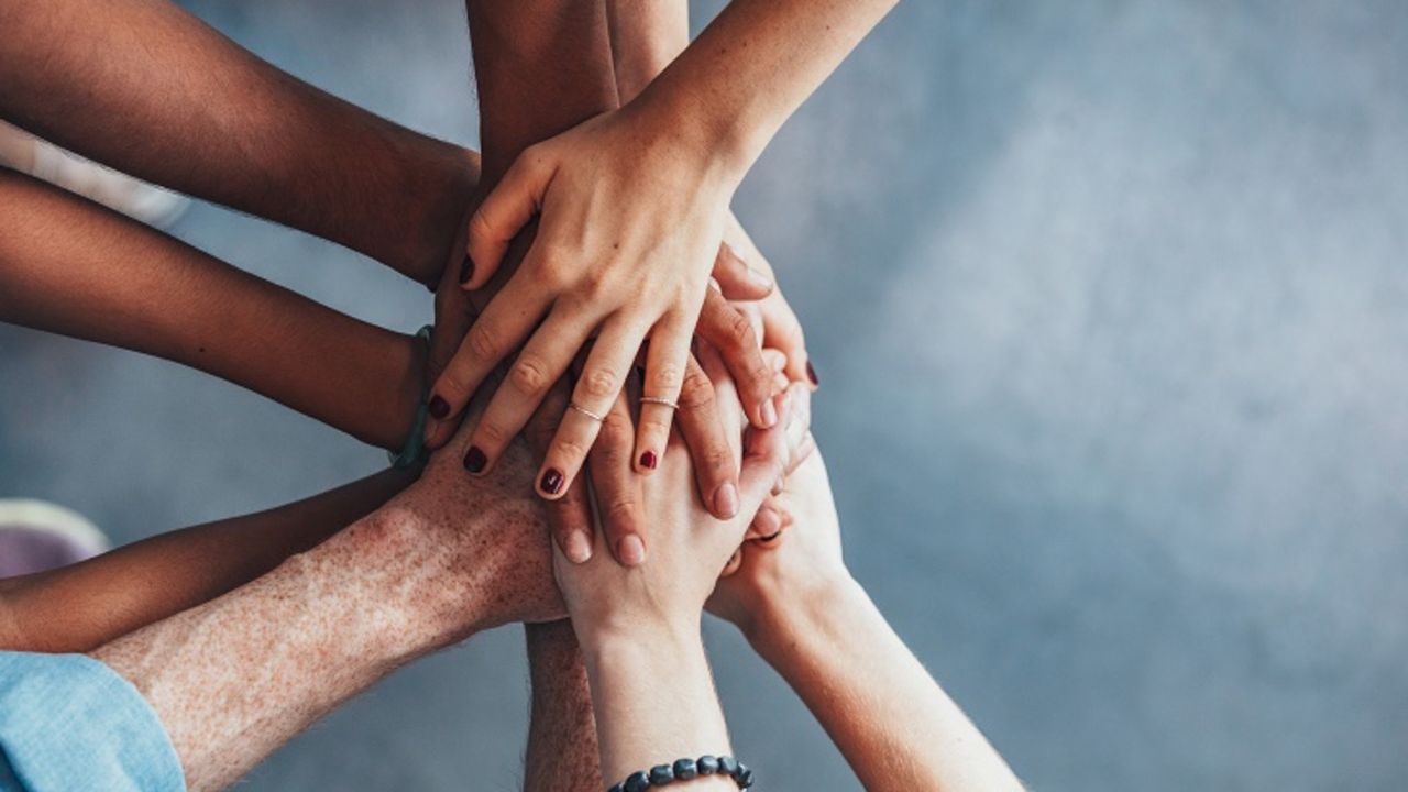 Hande übereinandergelegt in Gruppe