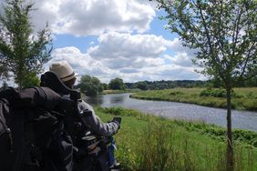 Rollstuhlnutzerin blickt auf Fluss, Perspektive aus ihrer H&ouml;he, allerdings von hinten
