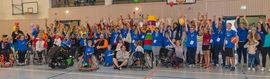 Sportler stehen und jubeln mit und ohne Behinderung