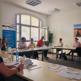 Foto mit Blick auf sitzende Teilnehmer, die im Gespr&auml;ch sind