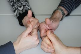 vier Daumen als Gruppe hochgestreckt zum Zeichen "wir schaffen das"