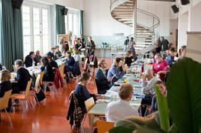 Blick auf Teilnehmer an mehreren Tischen