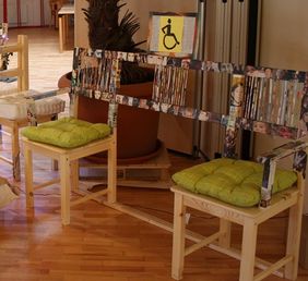 Holzbank mit zwei Sitzen und in der Mitte Platz f&uuml;r den Rollstuhl