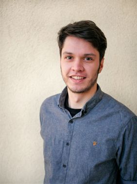 Junger mann mit kurzen Haaren, freundlichem L&auml;chenln, blauem Hemd